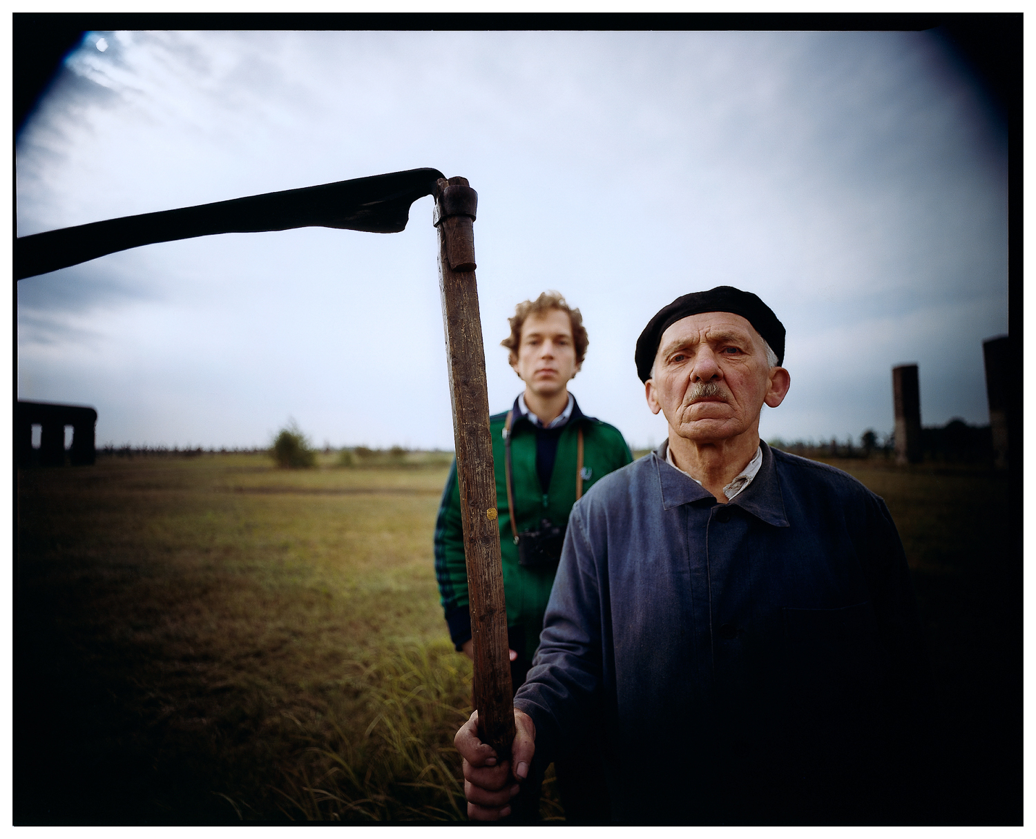 James Friedman, Local resident with scythe and self-portrait, Auschwitz II (Birkenau) concentration camp, Oswiecim, Poland, 1983. Photograph, 16 x 20 inches. Courtesy of the artist
