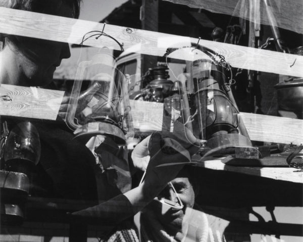 Robert C. May, Untitled [Fence, lanterns, and figures], 1968. Gelatin silver print, 6¹⁄₁₆ x 6 inches. Courtesy of The Art Museum at the University of Kentucky, Lexington